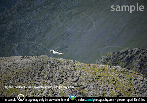 helicopetr hovering over mountain summit